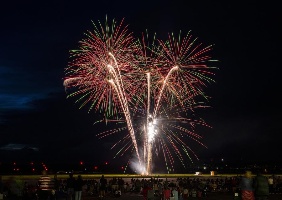 Multi-break shells opening above a Fourth of July crowd